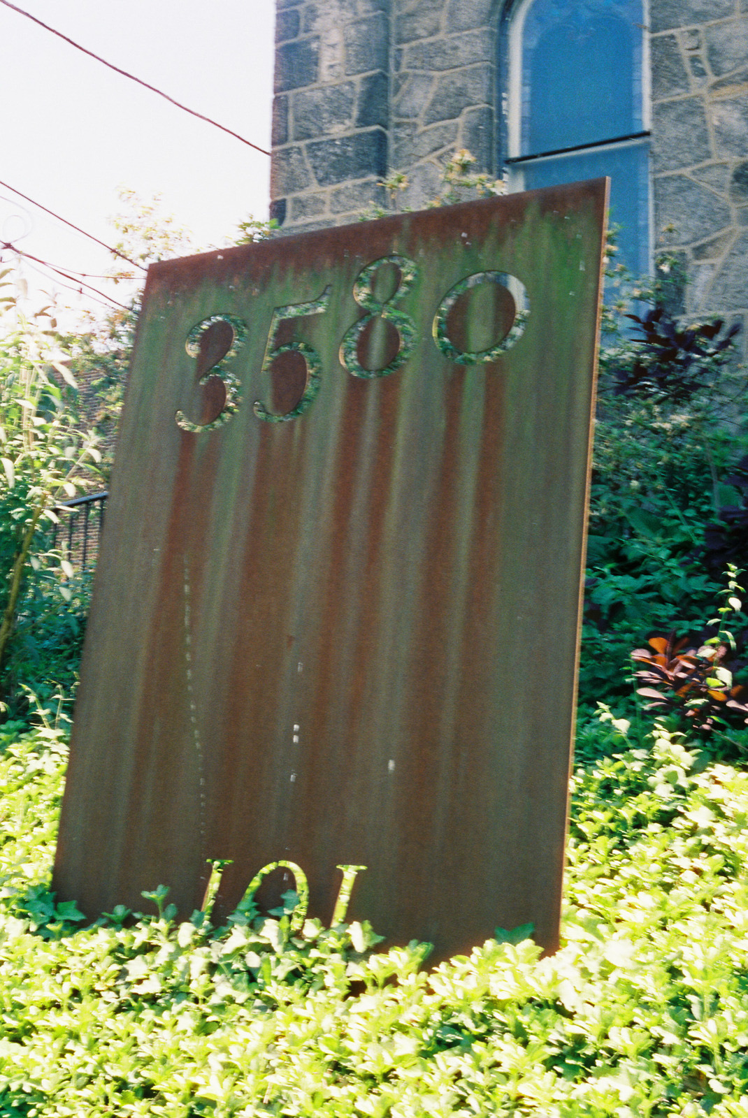 The rusted steel 3580 sign in the garden by the gate